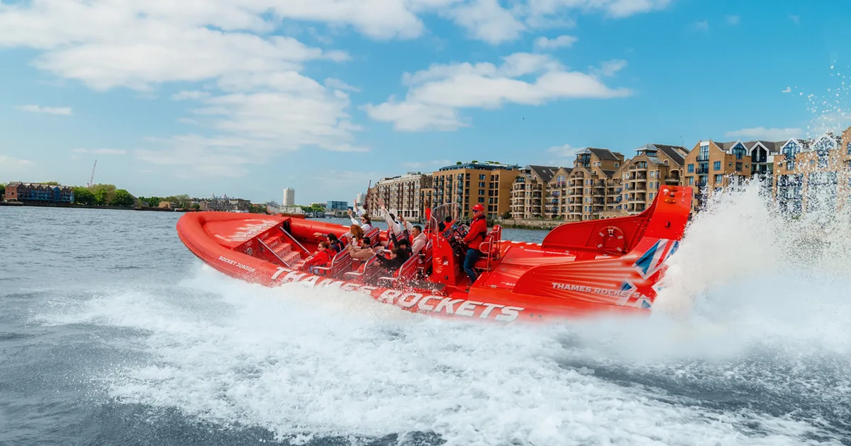 A red Thames Rockets speedboat at speed on the River Thames in London